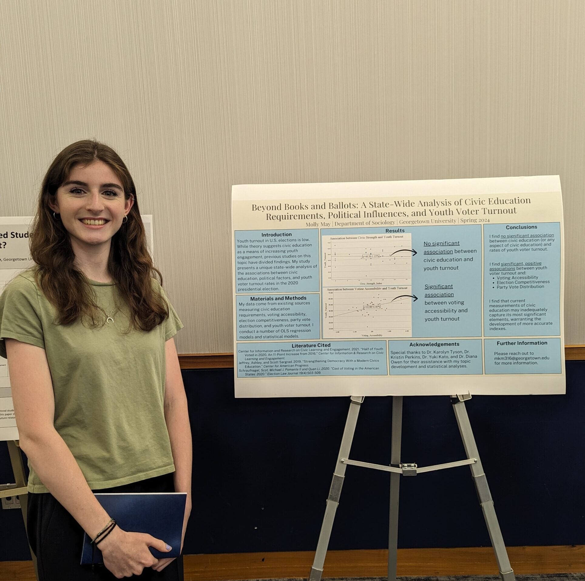 CERL Research Assistant and Georgetown University undergraduate Molly May stands before her Senior Thesis presentation poster.