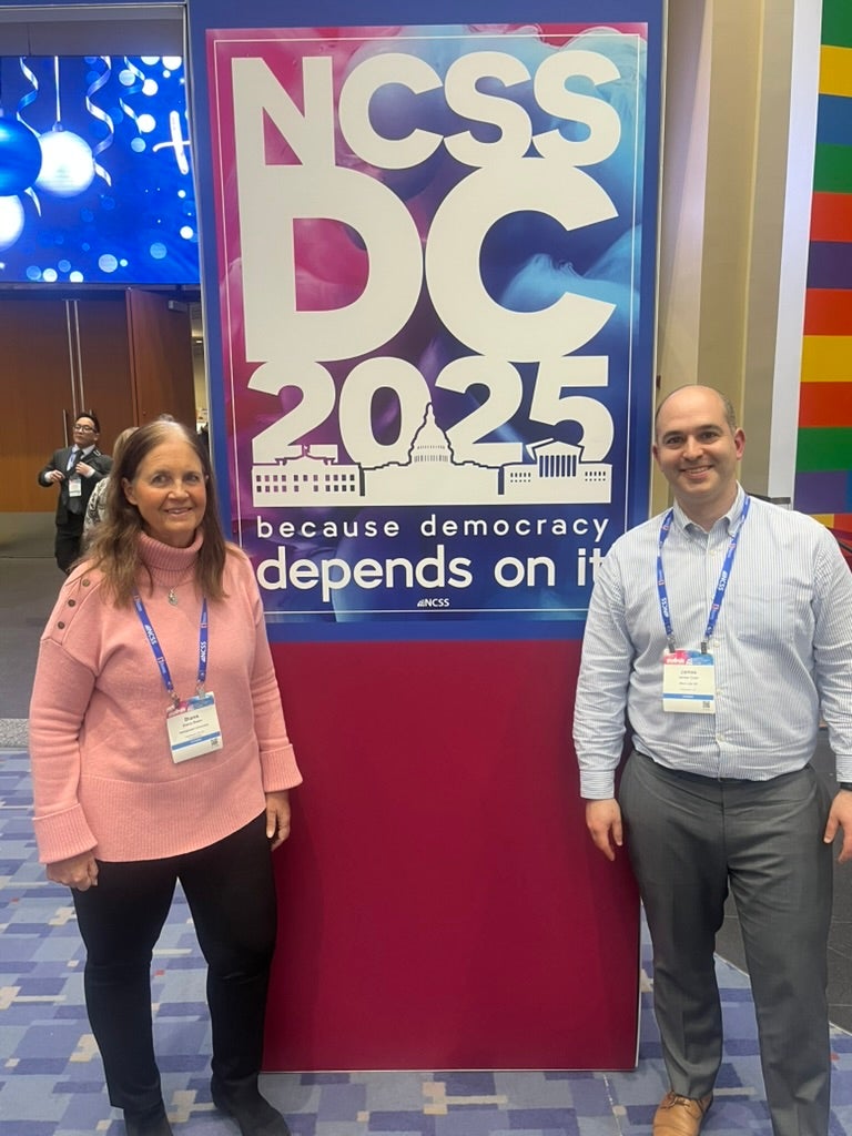 Dr. Diana Owen and James Coan stand before NCSS conference poster Dr. Diana Owen and James Coan stand before NCSS conference poster